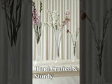 Hand-crafted glass vases with flowers, showcasing elegance and durability.