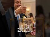 Person holding a decorative lantern with an easy-carry rope handle.