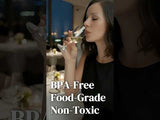 Woman enjoying a drink in a sophisticated restaurant setting.