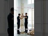 Two men adjusting a wooden stand with adjustable heights in a bright room.