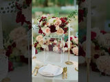Elegant floral centerpiece with roses and greenery on a table setting.