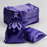 Purple satin drawstring bags stacked and displayed on a white background.