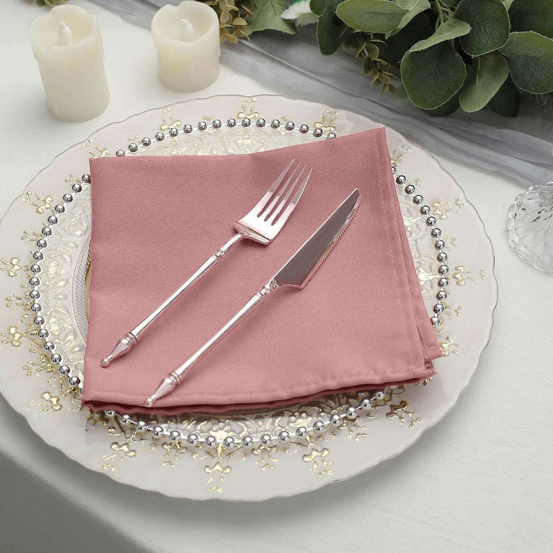 Pink napkin on ornate charger plate with silverware