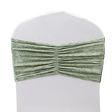 Green velvet chair cover with gathered fabric detail.