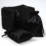 Black satin drawstring bags stacked on a white background.