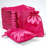 Stack of pink satin bags in various sizes on a white background.