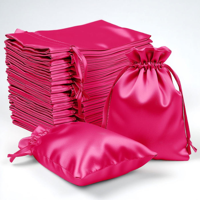Stack of pink satin bags in various sizes on a white background.