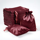 Burgundy satin drawstring bags and fabric squares stacked on a white background