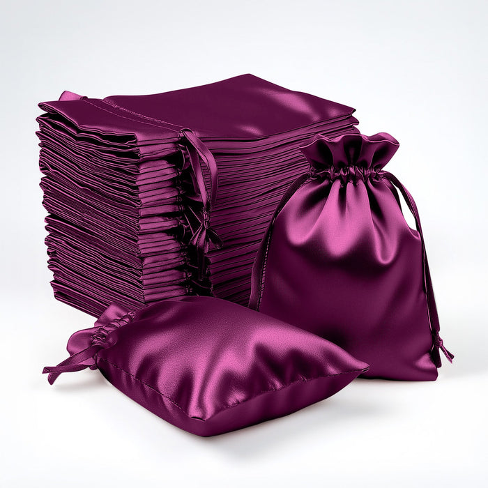 Stack of purple satin drawstring bags on white background