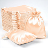 Set of satin drawstring bags in peach color for storage or gifting