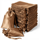 Stack of elegant brown satin drawstring bags on a plain white background.