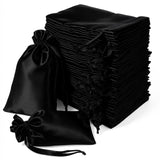 Stack of elegant black satin bags with drawstring closures