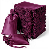 Stack of elegant purple satin drawstring bags for gifts and storage