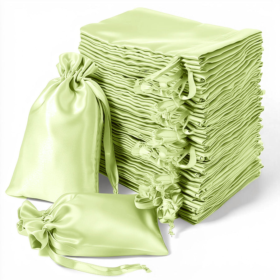 Stack of light green satin drawstring bags on a white background.