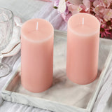 Pink pillar candles on a marble tray with floral accents.