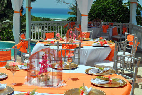 Orange-and-white poolside tablescape with ocean view