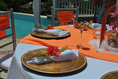 Place setting with orange tablecloth and gold charger