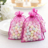 Colorful pastel candy in pink mesh bags on a table
