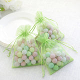 Pastel candy-filled organza bags on a light table setting.