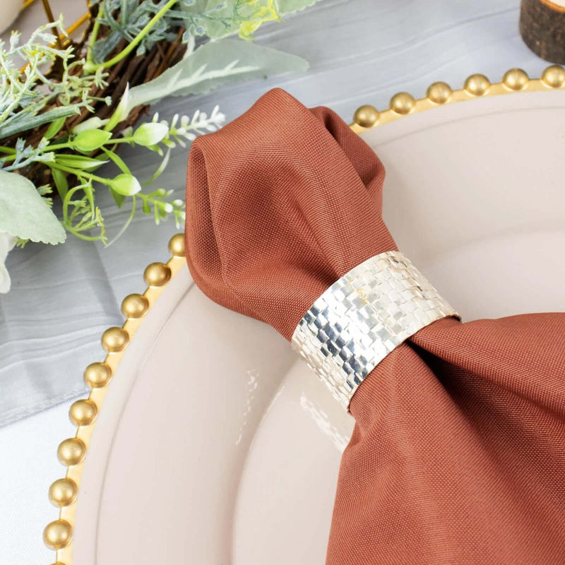 Terracotta napkin with silver napkin ring on a place setting