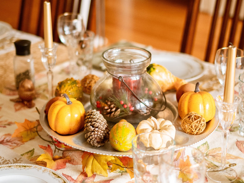 Thanksgiving table with pumpkins and glass centerpiece