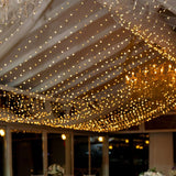 Elegant twinkling fairy lights adorning a reception venue's ceiling.