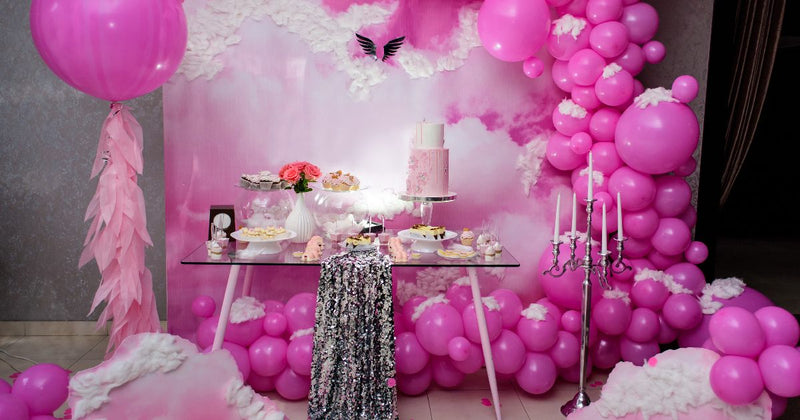 Pink balloon dessert backdrop with table and candles
