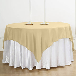 Add Elegance to Your Event with the 70"x70" Champagne Square Seamless Polyester Table Overlay