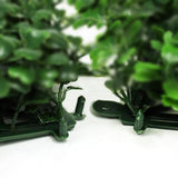 Green artificial plant arrangement on a white backdrop