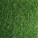 Artificial green foliage wall backdrop with small white flowers.