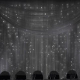 Elegant sheer curtain backdrop with twinkling lights for events and celebrations.