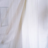 Sheer white fabric draping elegantly, creating a soft, airy atmosphere.
