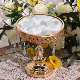 Elegant gold and crystal cake stand with a mirrored top and decorative lace trim.