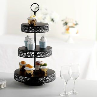 Black three-tier dessert stand with cupcakes and decorative treats.