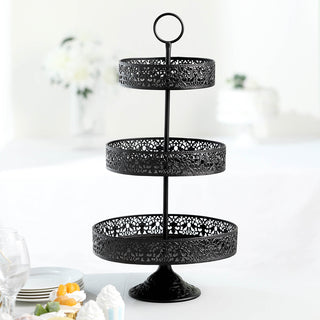 Black three-tiered serving stand with intricate cutout design.