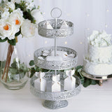 Silver three-tier serving stand with decorative design and gift boxes.