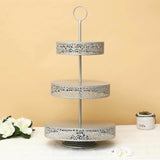 Three-tier decorative metal cake stand with intricate cutout design.