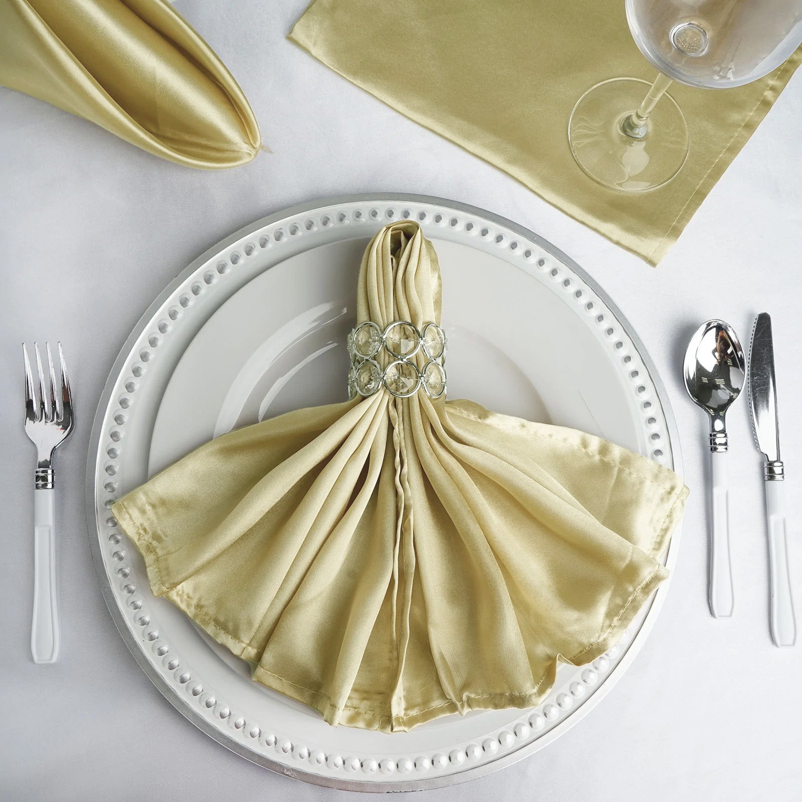 https://tableclothsfactory.com/cdn/shop/products/Champagne-Seamless-Satin-Cloth-Dinner-Napkins.jpg?v=1689407094