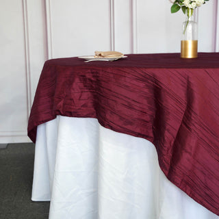 Create Unforgettable Events with Our Burgundy Accordion Crinkle Taffeta Square Table Overlay