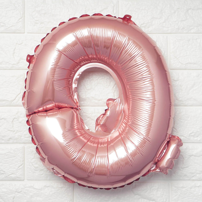 Rose gold number 0 balloon on a textured white background.