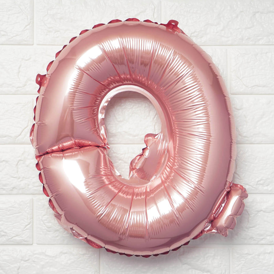 Rose gold number 0 balloon on a textured white background.