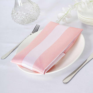 Pink and white striped napkin on a plate with silver utensils