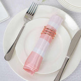 Pink and white striped napkin with rose gold napkin rings on a white plate.