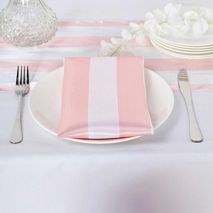 Pink striped napkin on a plate with silverware on a table setting.