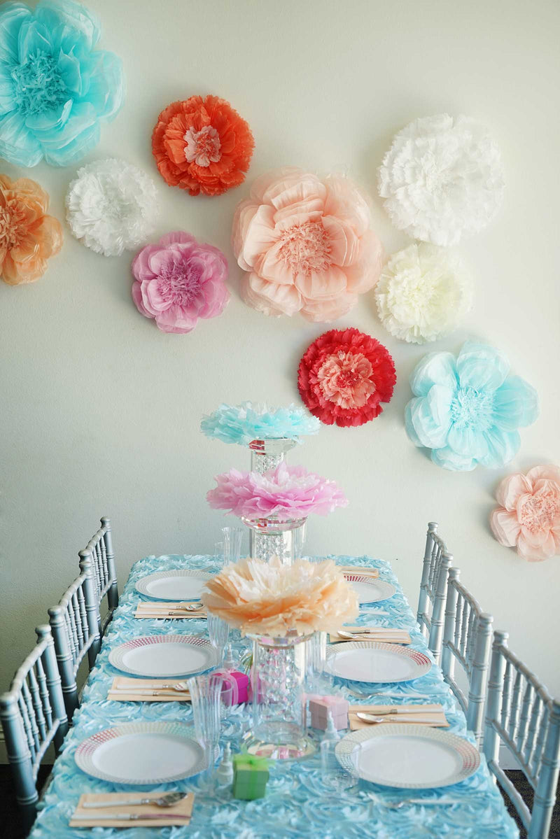 Colorful paper flowers arranged above a table setting