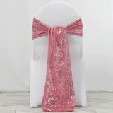 Pink sequin chair sash draped over a white chair.