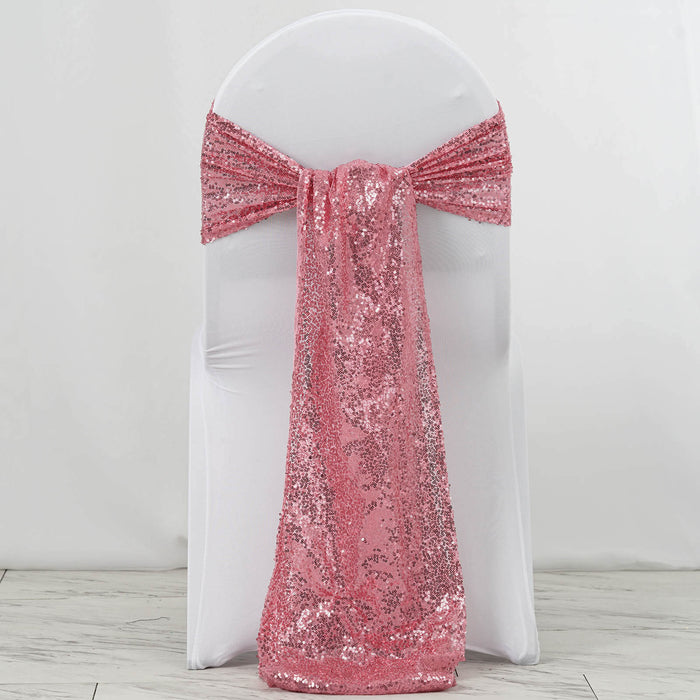Pink sequin chair sash draped over a white chair.