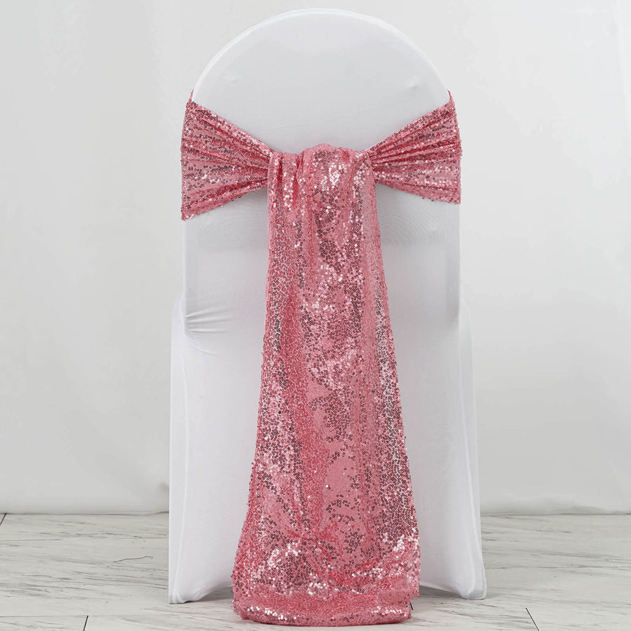 Pink sequin chair sash draped over a white chair.