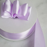 Light purple satin ribbon with bow on a white spool.