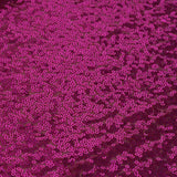 Vibrant pink sequin fabric texture with reflective details.